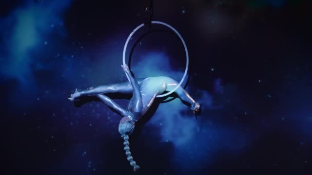 星空を背景にした空中輪で輝く衣装とハイヒールを身につけた柔軟な女性コンストラクター 驚異的なパフォーマンスの神秘的な雰囲気 静的ショット — ストック動画