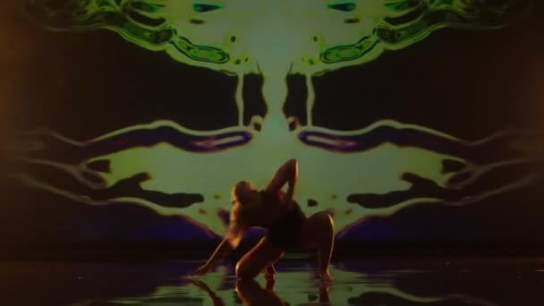 スタジオステージでロングヘアダンスをする芸術的な若い女性 ダークアニメーションを背景に活躍するダンサー — ストック動画