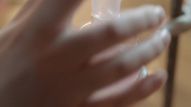 Bilim adamının şişenin içine fokurdayan sıvıyı koyarken yakın plan çekilmiş fotoğrafı.