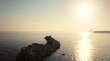 Hırvatistan 'ın Parlak Güneş Işığı Altında Dubrovnik sahilinden Kayalara ve Tekneye Uçan İHA Uçuşu