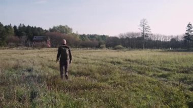 Yeşil Çayır Ormanı 'nda Sırt çantalı Kel Adam' ın Dönüşü. Kameradan Uzağa Yürür
