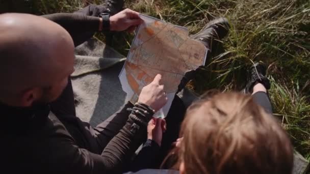 几个游客手里拿着一张纸片地图 核对一下路线 手持自顶向下镜头与相机旋转 — 图库视频影像