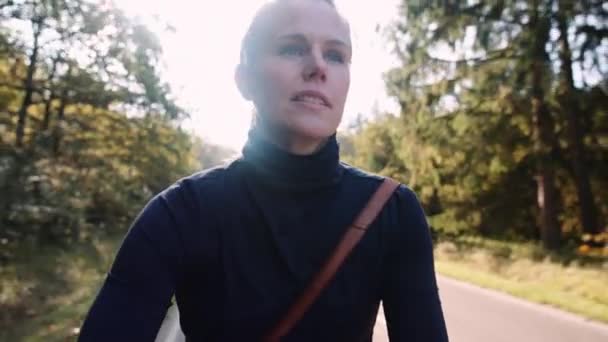 Sabah Güneşinin Yumuşak Işığında Asfalt Yolda Bisiklete Binen Bir Kadın — Stok video