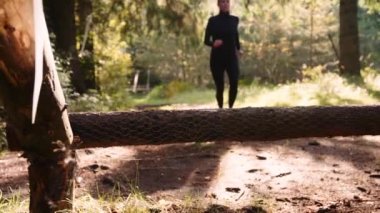 Atletizm Kadını Sabah Ormanında İleri Koşar ve Kütüğün Üzerinden Atlar. Yavaş Hareket Döndürme Görüntüsü