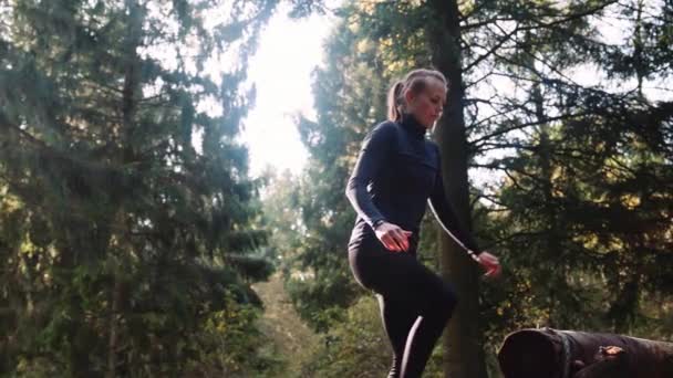 Atletka Běží Dopředu Skočí Přes Kládu Ranním Lese Panning Shot — Stock video