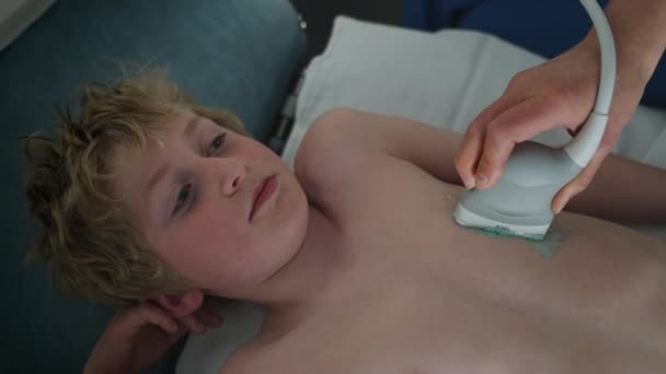 一名在医院接受超声心动图检查的男孩的特写 医生进行超声心脏检查 慢动作顶视图拍摄 — 图库视频影像