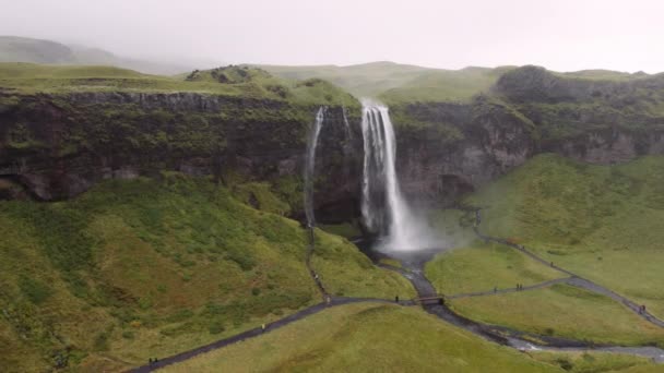 雄大なSeljalandsfoss滝の空中ビュー 水は力で落ちる アイスランドのハイランド地方の絶景 パノラマスローモーションショット カメラがゆっくりと右へ — ストック動画