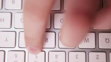 Beyaz ve Gümüş Klavyede Bir Şey Yazan Parmaklar 'ın Süper Yakın Çekimi. Tepeden tırnağa. Soldaki kamera kamyonu. Klavyeye odaklan