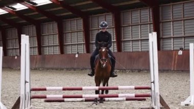 Binici Kadın, Salon Arena 'da Bir Engelin Üzerinden Atlamak İçin At Eğitti. Yavaş Hareket Sabit Çekim
