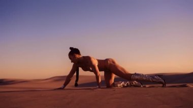Gümüş çizmeli ve Bikini 'nin çöl kumunda dört ayak üstünde emeklediği Geniş Yavaş Çekim Çekimi