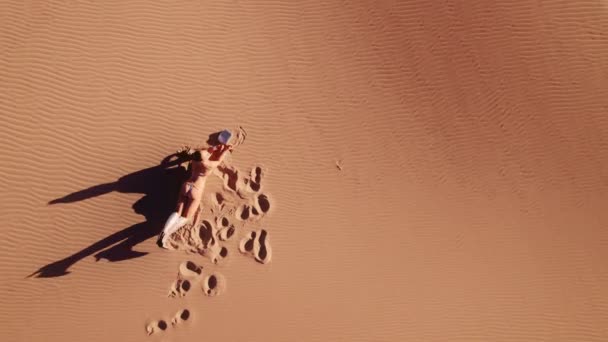 宽钻机下降到年轻女子躺在前面 在沙地上的靴子 — 图库视频影像