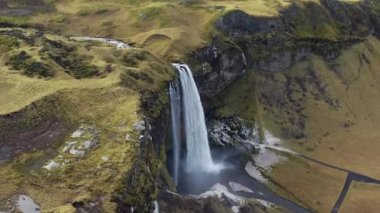 Manzaradan geniş insansız hava aracı uçuşu ve Seljalandsfoss Şelalesi İzlanda, Nehre dökülüyor.