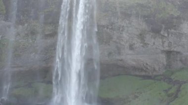 Geniş İHA Uçuşu Seljalandsfoss Şelalesi 'nden İzlanda' nın yukarısındaki araziye doğru yükseliyor.