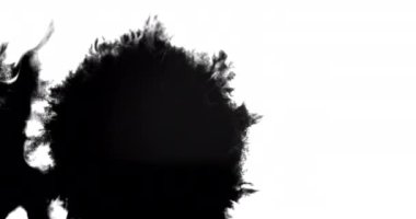 Beyaz yüzeye yayılan siyah mürekkebin yakın plan çekimi.