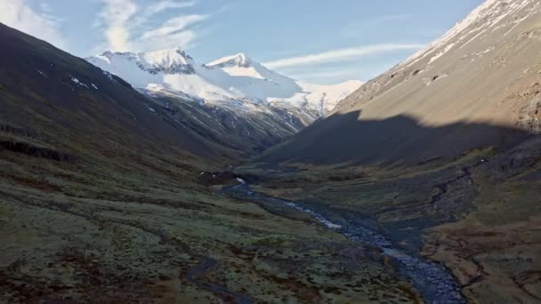 アイスランドの遠くに影と山がある谷のストリーム上の広いドローン飛行 — ストック動画