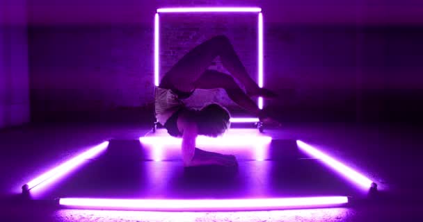 Lockdown Wide Shot Female Contortionist Surrounded Purple Light Leaning Elbows — Stok Video