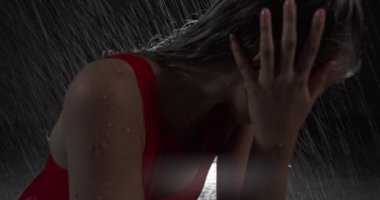 Baştan Çıkarıcı Kırmızı Elbiseli Genç Dansçı Karanlık Stüdyoda Sahne Işıklarına Karşı Çıplak Ayakla Sahne alıyor. Yağmur yağışını taklit ederek yere düşen su damlaları. Çekim dışı Dolly