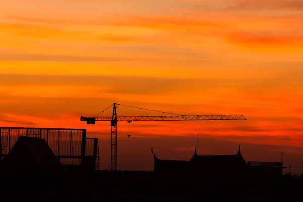 Industriële bouw kranen en gebouw bij zonsopgang — Stockfoto