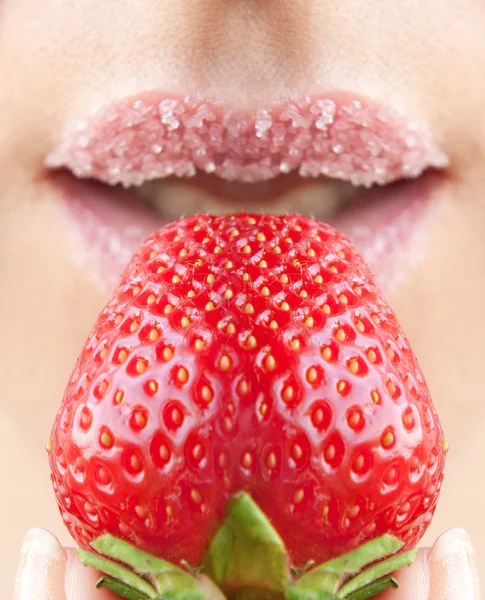 Woman's mouth with red strawberry covered with sugar — Stock Photo, Image