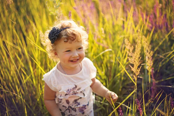 Усміхнена дівчинка на полі — стокове фото
