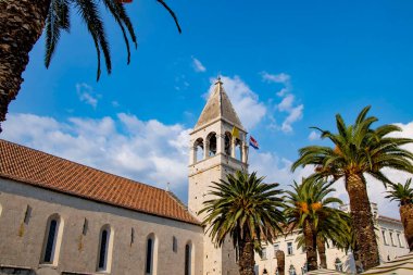 Eski Venedik kenti Trogir, Hırvatistan 'ın rıhtımındaki güneşli gezinti alanındaki belediye binasının manzarasını kapat.