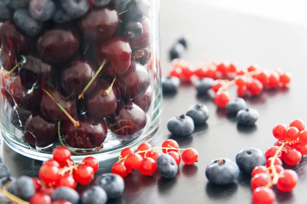 Blueberry, cherry and redcurrant in big glass — Stock Photo, Image