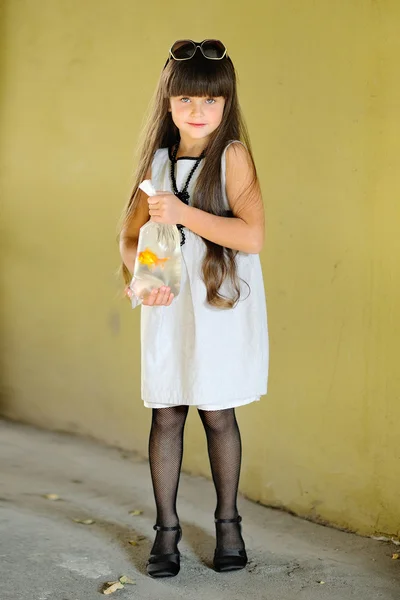 Portrait of little girl outdoors with a goldfish — Stock Photo, Image