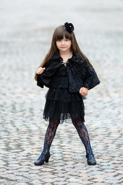Açık havada siyah elbiseli küçük kız portresi — Stok fotoğraf