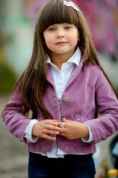 Портрет маленькой девочки на улице в розовой куртке — стоковое фото