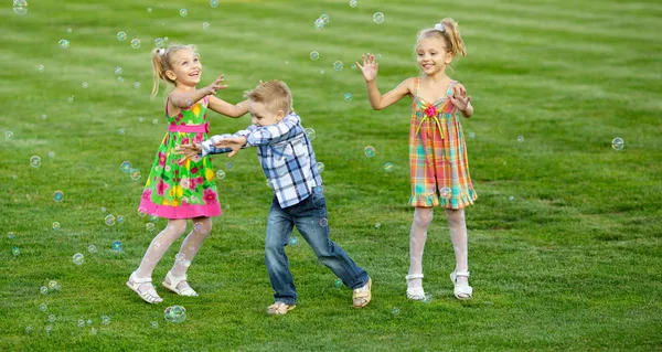 Portret van drie vrienden met zeepbellen — Stockfoto
