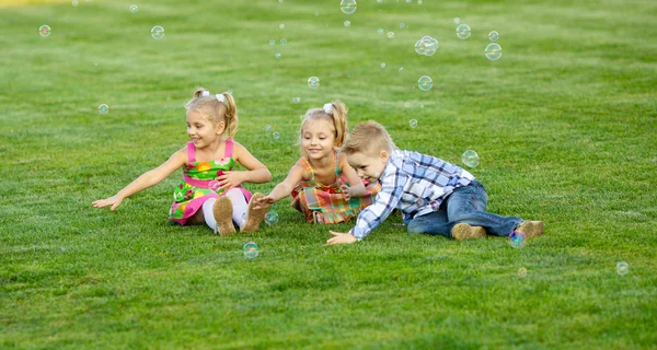 Retrato de tres amigos con pompas de jabón — Foto de Stock