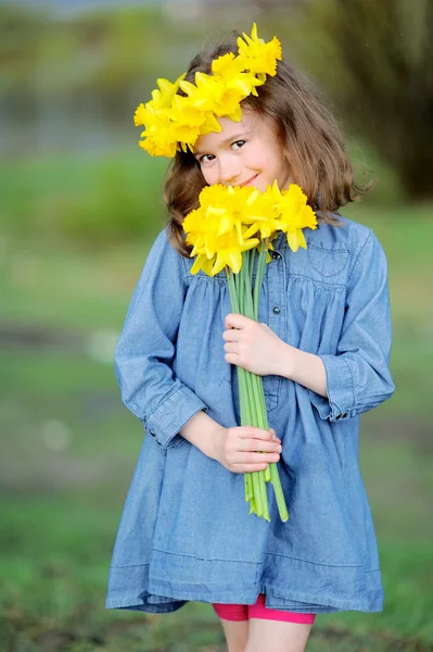 Porträtt av liten flicka utomhus med narcissus — Stockfoto