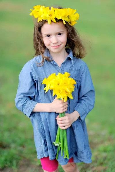 Porträtt av liten flicka utomhus med narcissus — Stockfoto