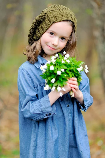 Porträtt av liten flicka utomhus med blommor — Stockfoto