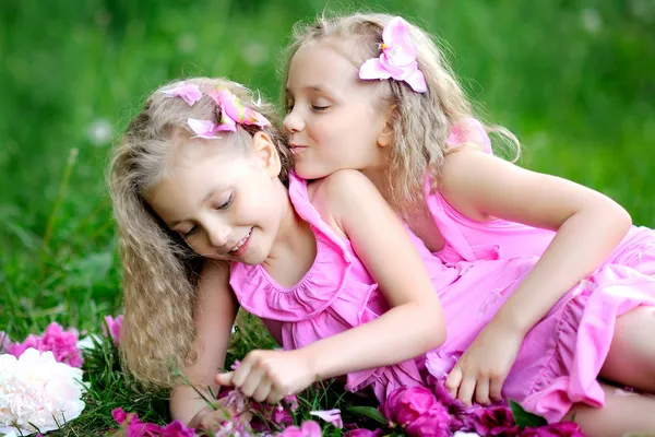 Portrait of two twins with peonies — Stock Photo, Image