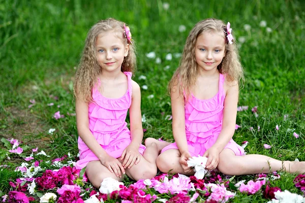 Portrait of two twins with peonies — Stock Photo, Image