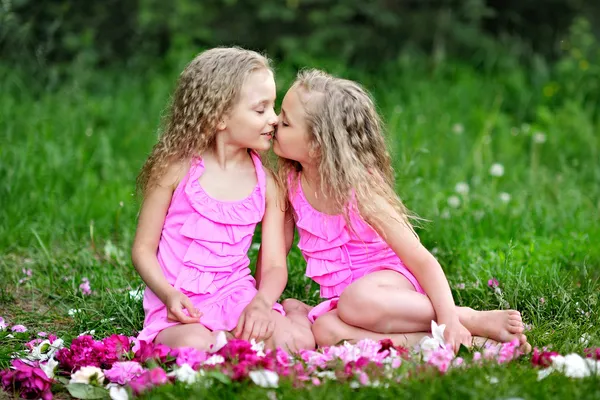 Portrait of two twins with peonies — Stock Photo, Image
