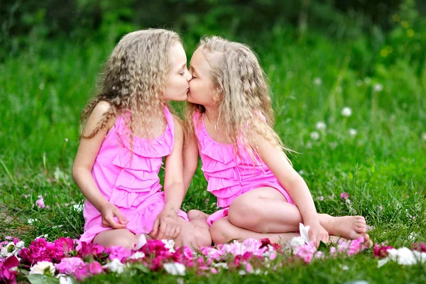 Portrait of two twins with peonies — Stock Photo, Image