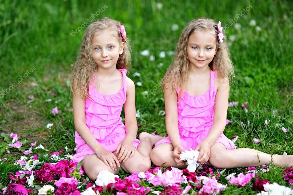 Portrait of two twins with peonies Stock Photo by ©zagorodnaya 39093371
