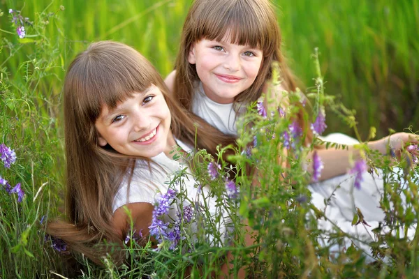 Portret dwóch młodych dziewczyn z kwiatami — Zdjęcie stockowe