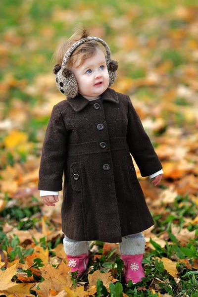 Portrait of a little girl in a park in autumn — Stock Photo, Image