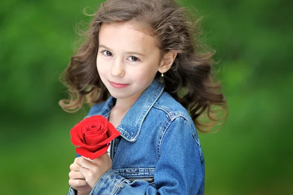 Porträtt av en vacker liten flicka med ros — Stockfoto