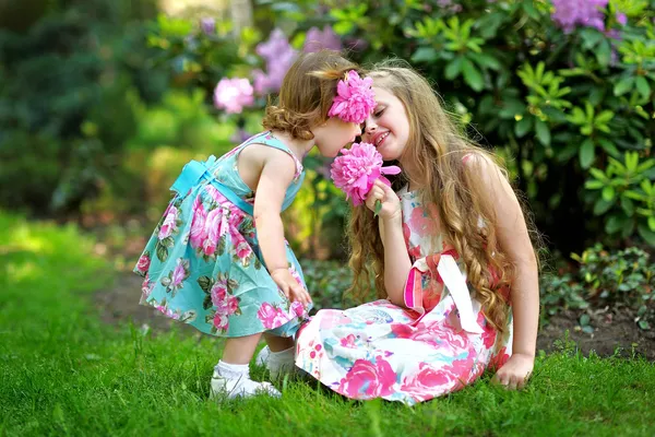 Portrait of two sisters in a park in spring — Stock Photo, Image