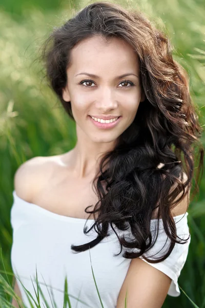 Mooie elegante brunette meisje in een veld — Stockfoto