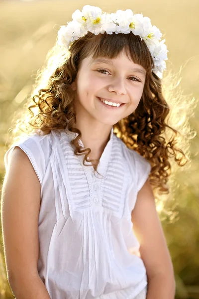 Portret van een mooi klein meisje in een veld — Stockfoto