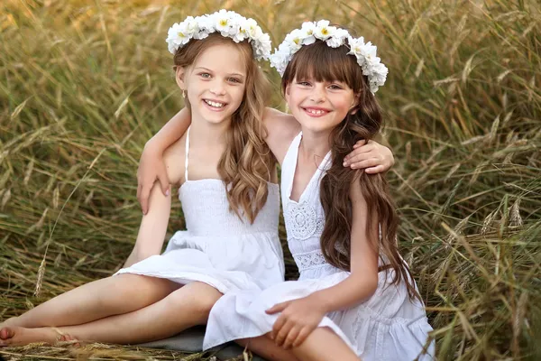 Portret van twee jonge meisjes met bloemen — Stockfoto