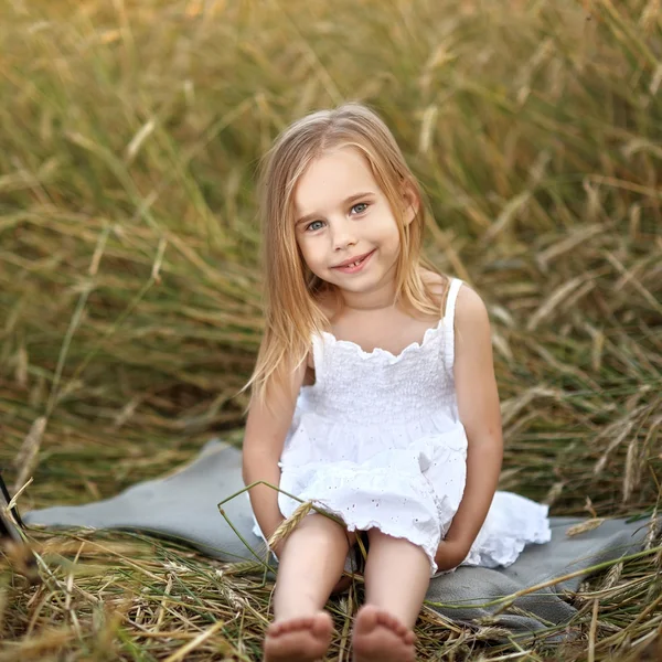 Portrait of a beautiful little girl in a field — Stock Photo, Image