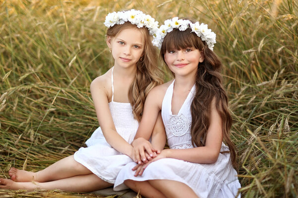 Portrait of two young girlfriends with flowers