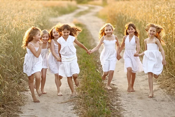 Портрет маленьких девочек, бегущих по полю — стоковое фото