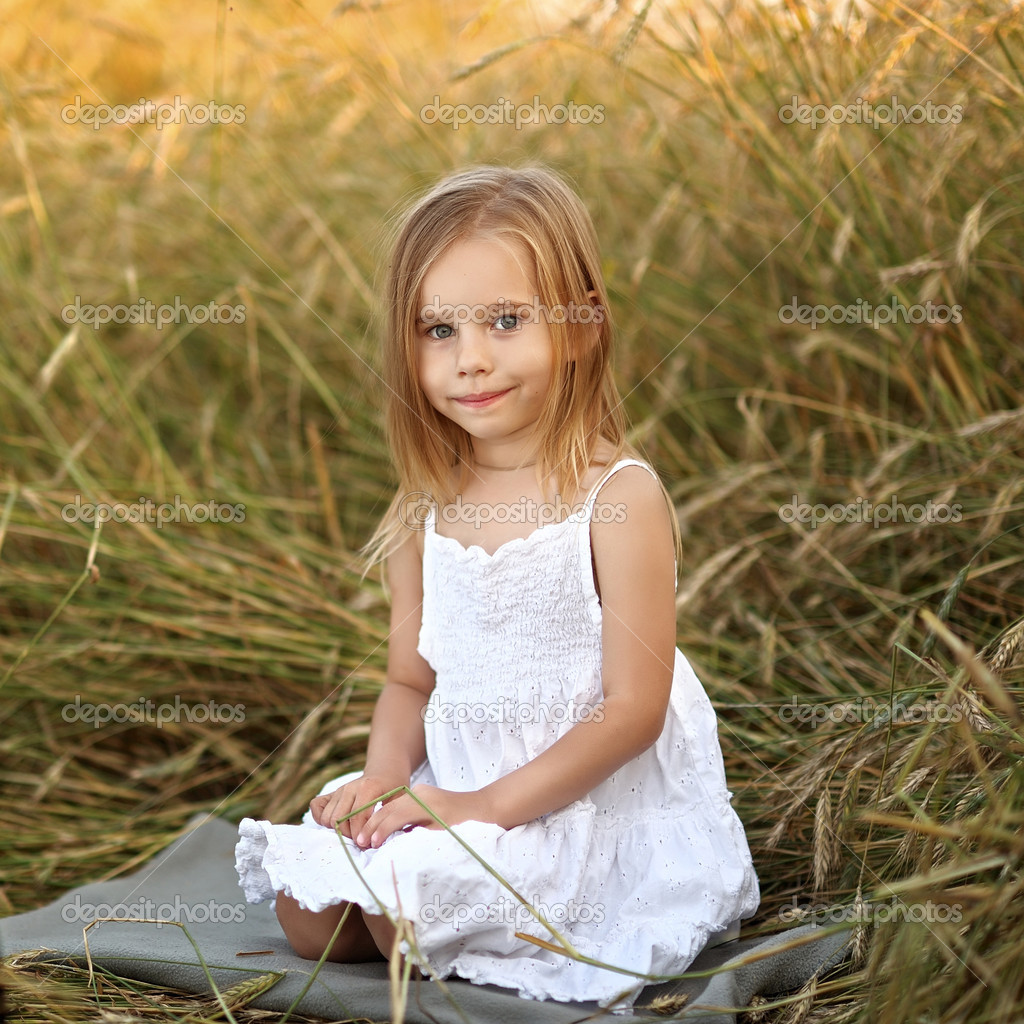Portrait of a beautiful little girl in a field Stock Photo by ...